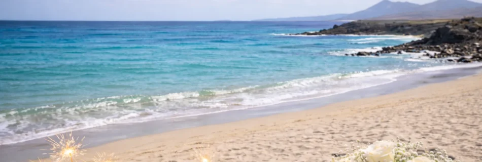Atmosfera romantica che richiama il sogno di sposarsi in spiaggia alle Maldive, con sabbia chiara, mare cristallino e dettagli eleganti